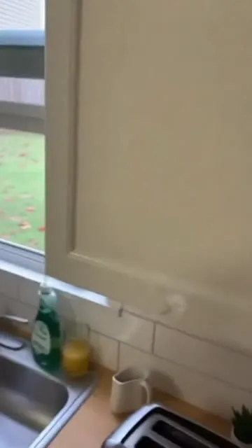 Toaster pops and a guy outside the window catches a cup